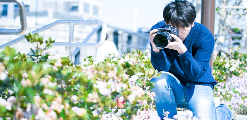 カメラを構えて写真撮影をしている男性